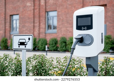 e-car charging station, e-car charge point or electric vehicle supply equipment (EVSE) with information sign electric car public charging point station and charge cable, charging plug parking spaces - Shutterstock ID 2279276553