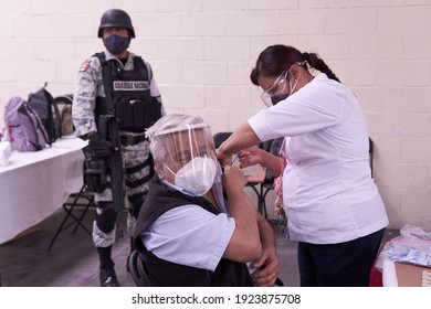 ECATEPEC DE MORELOS, MÉXICO, 24 FEBRUARY 2021: Vaccination Against Covid 19 In Ecatepec De Morelos, With A Nurse Vaccinating An Older Adult Guarded By The National Guard