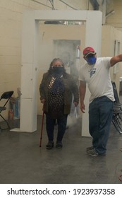  ECATEPEC DE MORELOS, MÉXICO, 24 FEBRUARY 2021: A 60-year-old Woman Entering The Covid 19 Vaccination Area In The Melchor Muzquiz Civic Center In Ecatepec, Going Through A Sanitizing Tunnel           