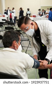  ECATEPEC DE MORELOS, MÉXICO, 24 FEBRUARY 2021: Young Doctor Taking The Pressure On An Elderly Adult Prior To His Vaccination Against Covid 19 At The Centro Civico Melchor Muzquiz In Ecatepec         