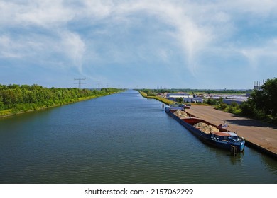 Echt, Netherlands - May 15. 2022: View from bridge on straight  maas inland waterway canal with sand cargo inland vessel 