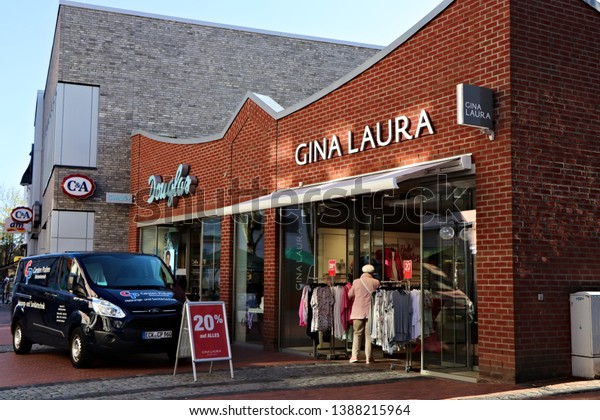 ECKERNFOERDE, GERMANY - APRIL 17 2019 Entrance sign\
of German shops of Douglas and GINA LAURA with a car parked in\
front of the\
shops