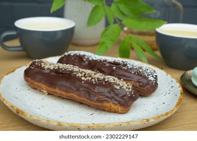 Eclairs with tea on a table in a cafe. Sweet food still life.
