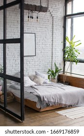 Eclectic Schlafzimmer Inneneinrichtung mit tropischen Pflanzen. Weiße Ziegelwand und Holzboden.