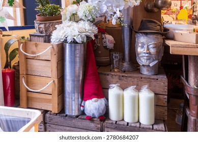 Eclectic collection of decor items including wooden crates, candles, a gnome, and a decorative bust in a shop.