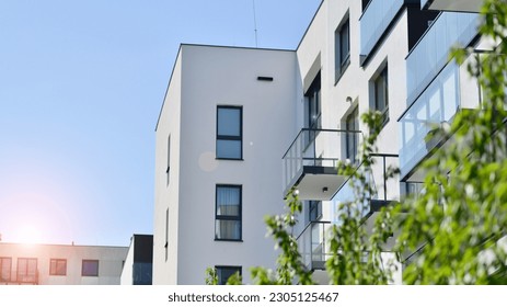 Eco architecture. Green tree and new residential building. Harmony of nature and modernity. Modern apartment building with new apartments in a green residential area.