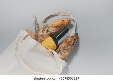 Eco Bag, Baked French Bread, Bottle Of Wine And Glasses On A Gray Background. Christmas Sustainable Lifestyle Concept. Top View. High Quality Photo