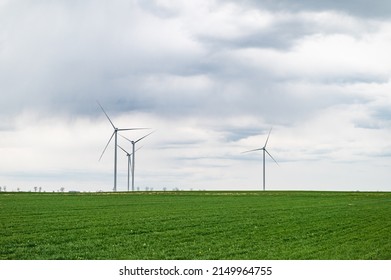 Eco Banner Or Header Image Of Three Wind Turbines Of A Wind Farm, Producing Renewable Energy. Clean Green Alternative Power. Wind Energy To Fight Climate Change And Global Warming.