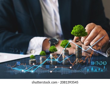 Eco Business Investment. Green Business Growth. Businessman Holding Coin With Tree Growing On Money Coin Stack. Finance Sustainable Development.Concept Of Pass And Increase Of Renewable Energy.