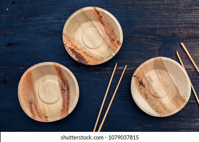 Eco, environment friendly disposable plate made from bamboo on dark wooden rustic background with chopsticks, top view, overhead - Powered by Shutterstock