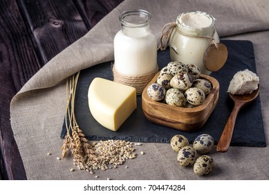 Eco farm products milk, cheese, sour cream, yogurt, eggs on dark wooden background. The concept of home made natural food