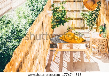 Eco friendly bamboo terrace. Orange pillows on the floor. 