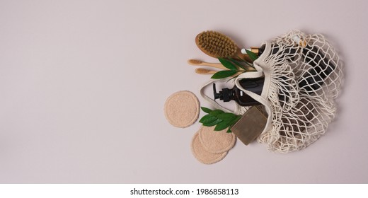 Eco friendly beauty products. Zero waste cosmetic products for face and body care, mesh bag and green leaves on pastel pink background - Powered by Shutterstock