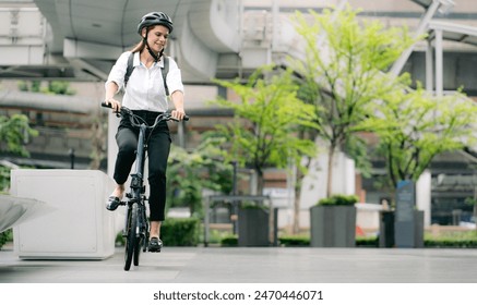 Eco friendly, businesswoman ride bicycle in urban to reduce carbon footprint. Beautiful woman environment conservation person commuting with bicycling. Cycling, alternative transport for green energy. - Powered by Shutterstock