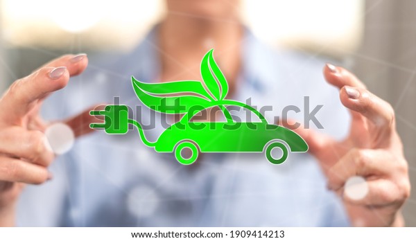 Eco friendly car concept between hands of a\
woman in background