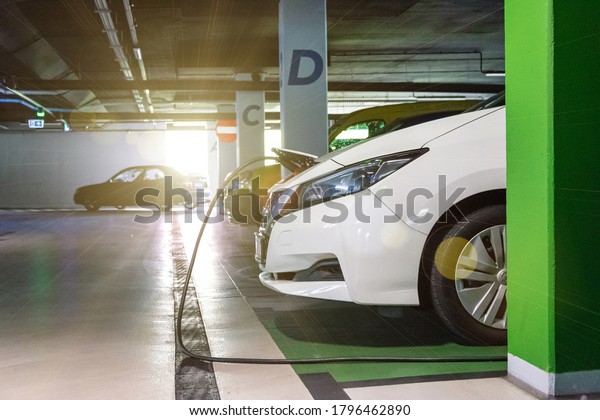 Eco friendly\
car. Hybrid vehicle - green technology of future. Electric car\
charge battery on eco energy charger station. Clean energy future\
of transportation ecology\
concept.