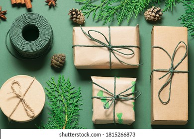 Eco Friendly Christmas Composition With Gift Boxes In Craft Reusable Paper And Natural Decor On Green Background Top View. Zero Waste Environmentally Friendly Christmas Concept.