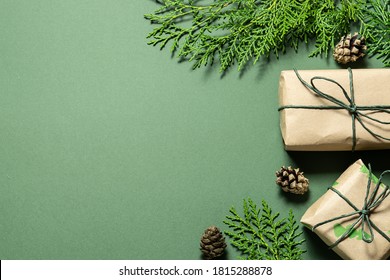 Eco Friendly Christmas Composition With Gift Boxes In Craft Reusable Paper And Natural Decor On Green Background Top View. Zero Waste Environmentally Friendly Christmas Concept.