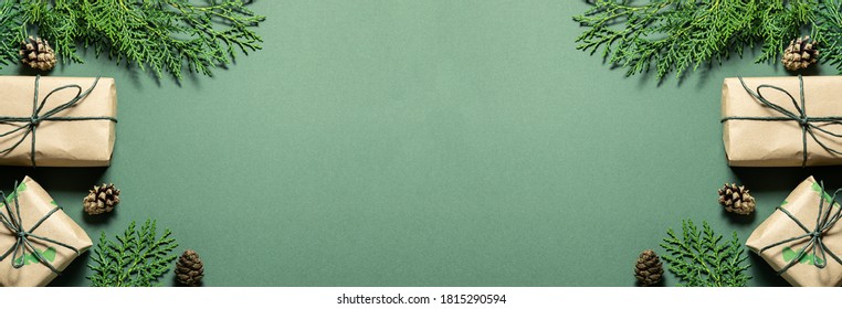Eco friendly Christmas composition with gift boxes in craft reusable paper and natural decor on green background top view. Zero waste environmentally friendly Christmas concept. Long banner format. - Shutterstock ID 1815290594