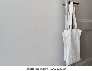 Eco friendly concept with white canvas tote bag hanging on door knob with two toned colored, Eco blank shopping sack with free copy space, Reduce plastic bags to reduce global warming. Canvas tote bag - Powered by Shutterstock