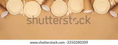 Eco friendly disposable dishware for takeout. Top border on a brown paper background. Biodegradable, composable alternative to plastic. Above view with copy space.