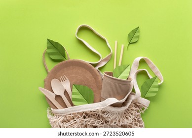Eco friendly disposable packaging and tableware with paper green leaves top view. Zero waste, sustainable lifestyle and plastic free concept. 