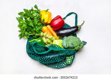 Eco friendly mesh shop bag with raw organic green vegetables isolated on white background Flat lay, top view Zero waste, plastic free concept Healthy clean eating diet and detox, agriculture concept - Powered by Shutterstock