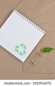 Eco friendly notebook with recycle symbol, wooden pencil with green leaf on pin, KRAFT envelopes. Office eco friendly. - Shutterstock ID 1955914375