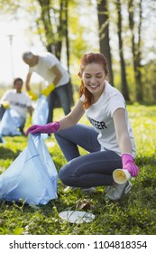 Eco Friendly. Pretty Female Volunteer Staring Down While Collecting Rubbish