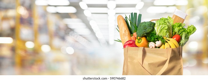 Eco friendly reusable shopping bag filled with vegetables on a blur background - Shutterstock ID 590746682