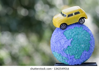 Eco Friendly Save World Concept. Yellow Car On Paper Mache Craft Earth Globe Natural Background. Ideas Of Earth Maintenance By Reducing Energy Consumption, Travel Around The World