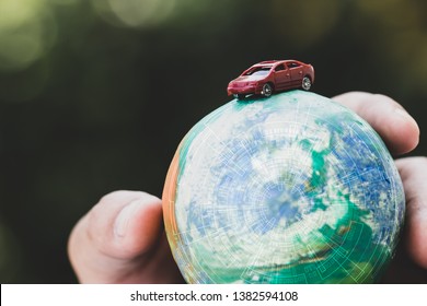 Eco friendly Save world concept. Red car and Hands holding Model globe clay with radar Natural background. Ideas of earth maintenance by reducing energy consumption, Travel around the world