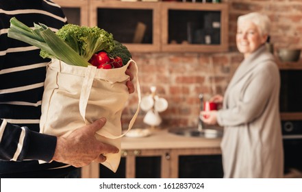 Eco friendly shopping. Senior couple unpacking fabric bag with organic food, panorama - Powered by Shutterstock