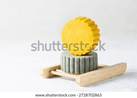 Eco friendly solid handmade bright green and yellow shampoo bars on light background close-up