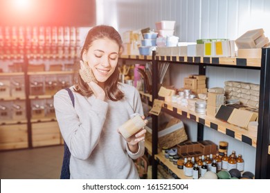 Eco friendly vegan woman customer chooses and buys handmade jute washcloths for washing dishes or body near rack with products in zero waste shop. Eco shopping at local business concept. - Powered by Shutterstock