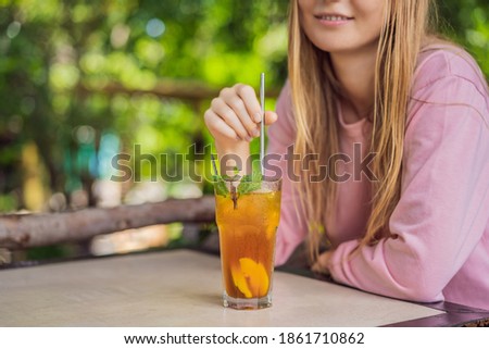 Eco friendly woman using reusable stainless steel straw to drink fruit tea