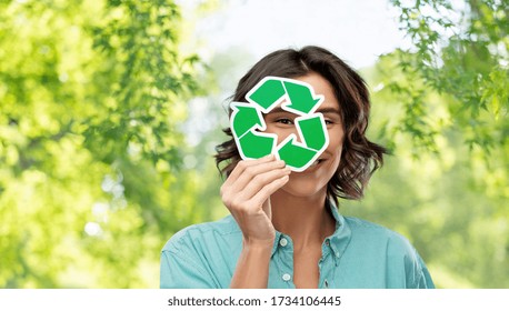 eco living, environment and sustainability concept - portrait of happy smiling young woman in turquoise shirt looking through recycling sign over green natural background - Shutterstock ID 1734106445