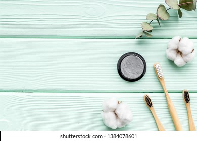 Eco Materials Concept With Bamboo Tooth Brush And Toothpaste With Bamboo Carbon On Mint Green Background Top View Mockup