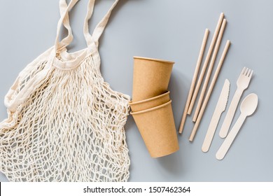 eco natural paper cups, straws, bag flat lay on gray background. sustainable lifestyle concept. zero waste, plastic free items. stop plastic pollution. Top view, overhead, template, Mockup.