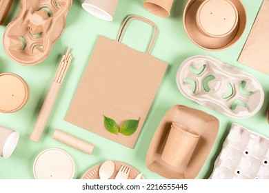 Eco Paper Utensils Bundle - Food Containers, Paper Bag And Cup Holders, Coffee Cups Over Light Green Background. Sustainable Food Packaging Concept. Flay Lay Style