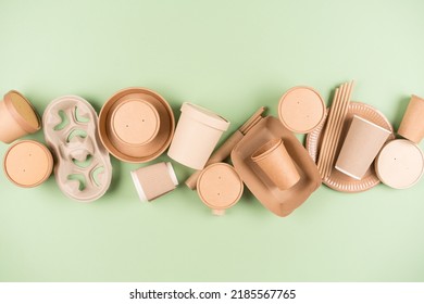 Eco Paper Utensils And Disposable Tableware, Food Containers, Paper Drinking Straws And Paper Cups Over Light Green Background. Sustainable Food Packaging Concept