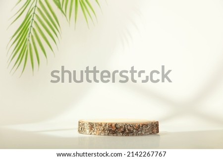 Eco rustic pine tree wood disc platform podium and tropical leaf on white light and shadow copy spase background. Minimal empty display product presentation scene