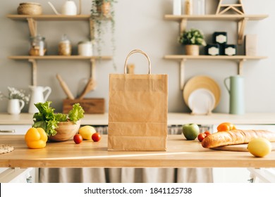 Eco Shopping Paper Bag With Fresh Vegetables And Baguette On The Table In Modern Kitchen. Food Delivery Or Market Shopping Concept.