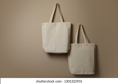 Eco tote bags hanging on color wall. Space for design - Powered by Shutterstock