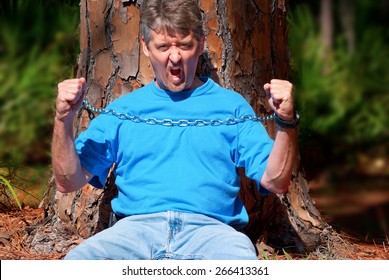 Eco Warrior Chained To A Tree To Stop The Tree From Being Cut Down And To Protest Deforestation