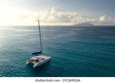Eco yacht catamaran sailing in ocean at sunset. Aerial view
