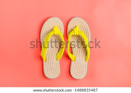 Eco yellow bamboo flip flops on living coral background Flat lay, top view. Zero waste, plastic free, holiday, summer, vacation concept. 