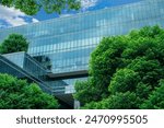 Eco-friendly building in the modern city. Sustainable glass office building with trees for reducing heat and carbon dioxide. Office building with green environment. Corporate building reduce CO2. 