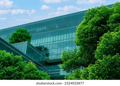 Eco-friendly building in the modern city. Sustainable glass office building with trees for reducing heat and carbon dioxide. Office building with green environment. Corporate building reduce CO2.  - Shutterstock ID 2324033877