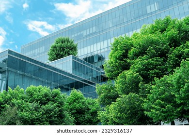 Eco-friendly building in the modern city. Sustainable glass office building with trees for reducing heat and carbon dioxide. Office building with green environment. Corporate building reduce CO2. 